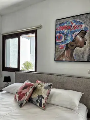 a bedroom with a painting of a woman with an umbrella at Charming House in the Heart of Limassol in Limassol