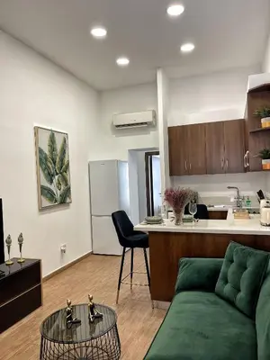 a living room with a green couch and a kitchen at Charming House in the Heart of Limassol in Limassol