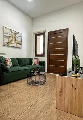 a living room with a green couch and a television at Charming House in the Heart of Limassol in Limassol