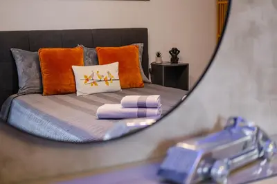 a mirror reflection of a bed in a bedroom at Fat Cow Apartments in Larnaka