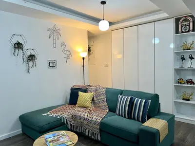 a living room with a green couch and a table at Fat Cow Apartments in Larnaka