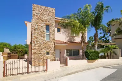 a house with a fence and palm trees at Villa Michaella - 500m from Golden Beach in Paralimni