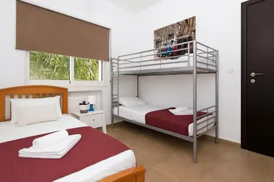 a bedroom with two beds and a bunk bed at Villa Michaella - 500m from Golden Beach in Paralimni