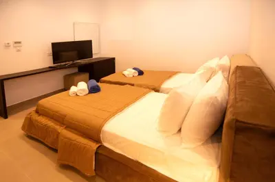 a hotel room with two beds and a television at Seafront Villa Layla by Ruidoso Luxury in Ayia Napa