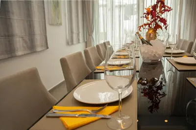a long table with plates and wine glasses on it at Seafront Villa Layla by Ruidoso Luxury in Ayia Napa