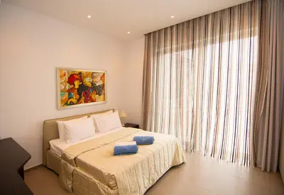 a bedroom with a bed with two blue towels on it at Seafront Villa Layla by Ruidoso Luxury in Ayia Napa