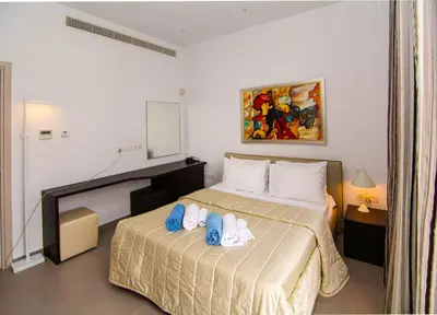 a bedroom with a bed with flip flops on it at Seafront Villa Layla by Ruidoso Luxury in Ayia Napa