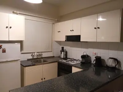 a kitchen with white cabinets and a black counter top at 2 bedroom apartment in Makenzi in Larnaka