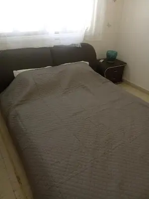 a bed with a comforter on it in a bedroom at 2 bedroom apartment in Makenzi in Larnaka
