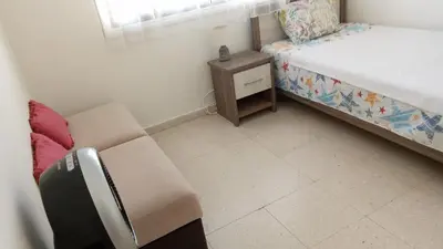a small bedroom with a bed and a chair at 2 bedroom apartment in Makenzi in Larnaka