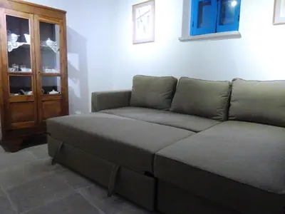a couch sitting in a living room next to a window at To Archontiko tis Anastasias in Athienou