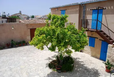 a tree in a courtyard in front of a building at To Archontiko tis Anastasias in Athienou