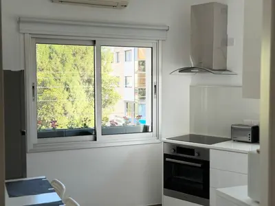 a white kitchen with a window and a stove at Anastasia 1 Bedroom Apartment in Limassol