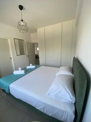 a bedroom with a large white bed with a green couch at Anastasia 1 Bedroom Apartment in Limassol