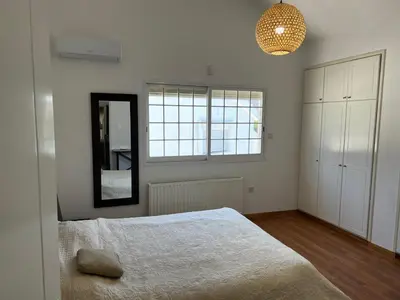 a bedroom with a large bed and a mirror at Villa Sawa by Ezoria Villas in Limassol