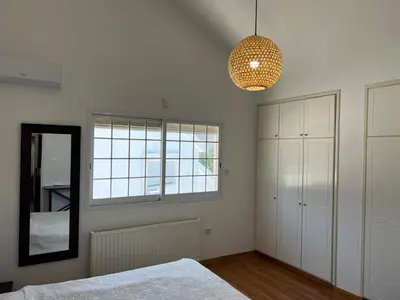 a bedroom with a bed and a mirror and a lamp at Villa Sawa by Ezoria Villas in Limassol