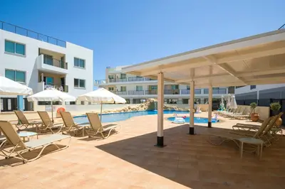 a swimming pool with lounge chairs and a pavilion at Sea View APT*Spacious balcony*200m to the Beach in Paralimni