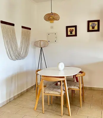 a table and chairs in a room with a lamp at Relaxing Gateway in Limassol in Episkopi Lemesou