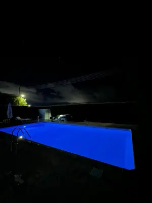 a blue swimming pool lit up at night at Relaxing Gateway in Limassol in Episkopi Lemesou