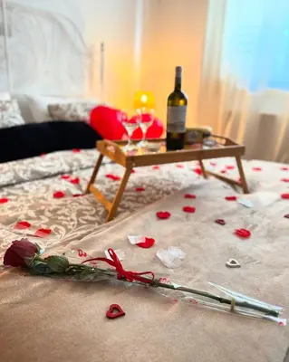 a bed with roses and a table with a bottle of wine at Stou Stefani in Agros