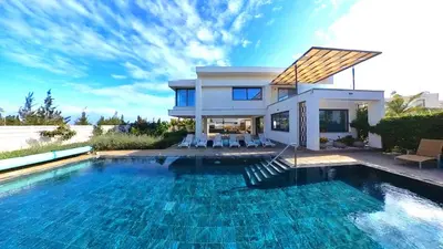 a house with a swimming pool in front of a house at Billy's Place Protaras Luxury Villa with private pool with heated pool option for autumn and winter months in Paralimni