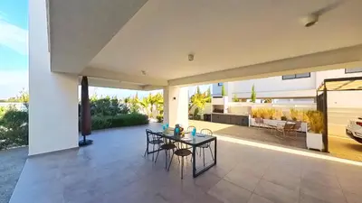 a patio with a table and chairs in a house at Billy's Place Protaras Luxury Villa with private pool with heated pool option for autumn and winter months in Paralimni