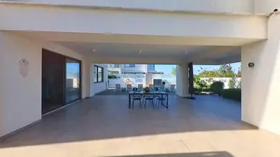 a patio with a table and chairs in a house at Billy's Place Protaras Luxury Villa with private pool with heated pool option for autumn and winter months in Paralimni