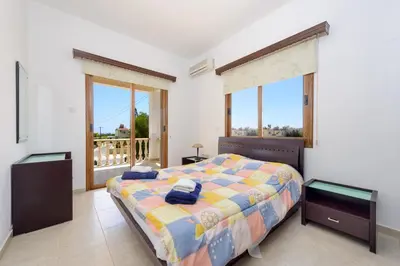 a bedroom with a bed and a large window at Villa Sam in Ayia Napa