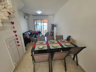 a dining room table and chairs in a living room at Mattis Seafront Beachhouse in Pervolia