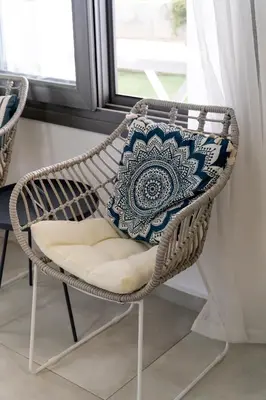 a wicker chair with a blue and white pillow on it at Meneou Blu Beach House* in Meneou