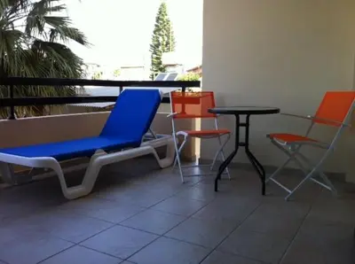 a room with chairs and a table and a table and chairs at St. Lazaros Seaside Apartment in Larnaka