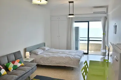 a bedroom with a bed and a couch and a window at Stadem Studios in Larnaka