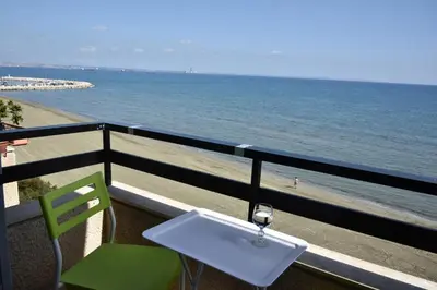 a balcony with a table and chairs and the beach at Stadem Studios in Larnaka