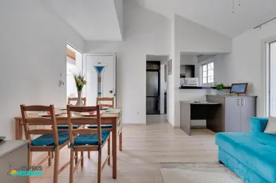 a dining room and living room with a table and chairs at Oroklini Star 200metres from the sandy beach in Larnaka