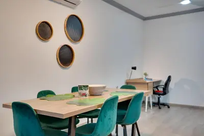a dining room with a wooden table and green chairs at Oroklini Star 200metres from the sandy beach in Larnaka