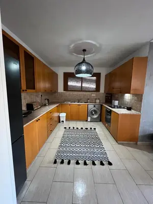 a kitchen with wooden cabinets and a rug on the floor at Green Door Apartment in Limassol