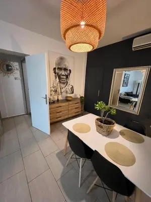 a dining room with a table with chairs and a picture of a man at Green Door Apartment in Limassol