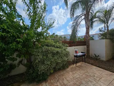 a table sitting on a patio next to a fence at Sidra's Apartment in Paralimni