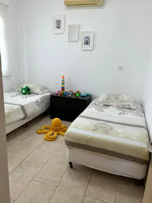 a bedroom with two beds and a stuffed animal on the floor at Sidra's Apartment in Paralimni