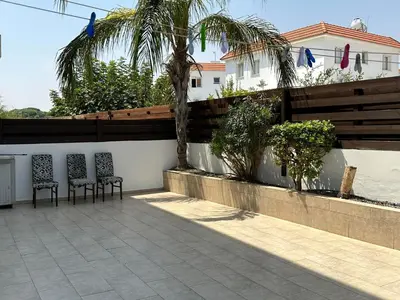 two chairs sitting on a patio in front of a wall at Sidra's Apartment in Paralimni