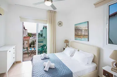 a bedroom with a bed with two towels on it at Villa Cayenne in Protaras