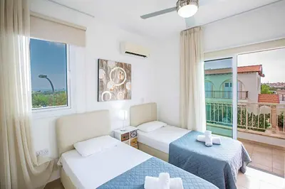 a hotel room with two beds and a window at Villa Cayenne in Protaras