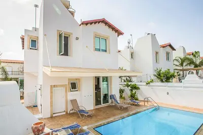 a villa with a swimming pool and a house at Villa Cayenne in Protaras