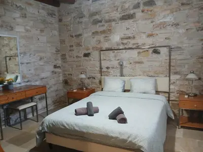 a bedroom with a bed with two slippers on it at Skarinou's Landhouse Poolside Heaven Apartment in Skarinou