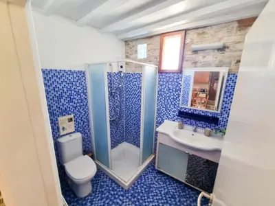 a blue bathroom with a toilet and a sink at Skarinou's Landhouse Poolside Heaven Apartment in Skarinou