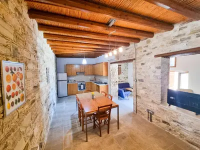 a kitchen and dining room with a wooden table and chairs at Traditional Village Pool Paradise Family Apartment in Skarinou