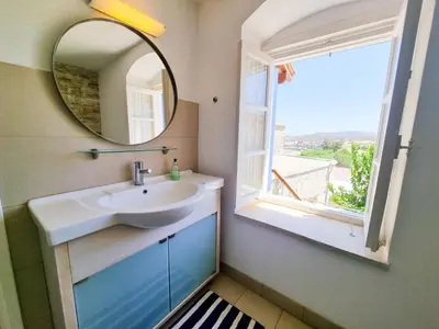 a bathroom with a sink and a mirror and a window at Village Charm with Pool Apartment at Skarinou in Skarinou