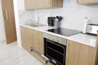 a kitchen with a stove and a sink at Musan Boutique Apartments in Ayia Napa