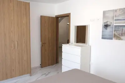 a bedroom with a dresser and a closet at Musan Boutique Apartments in Ayia Napa