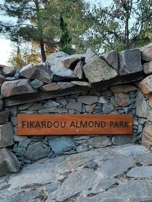 a park sign on a stone wall at FIKARDOU ALMOND PARK in Phikardhou